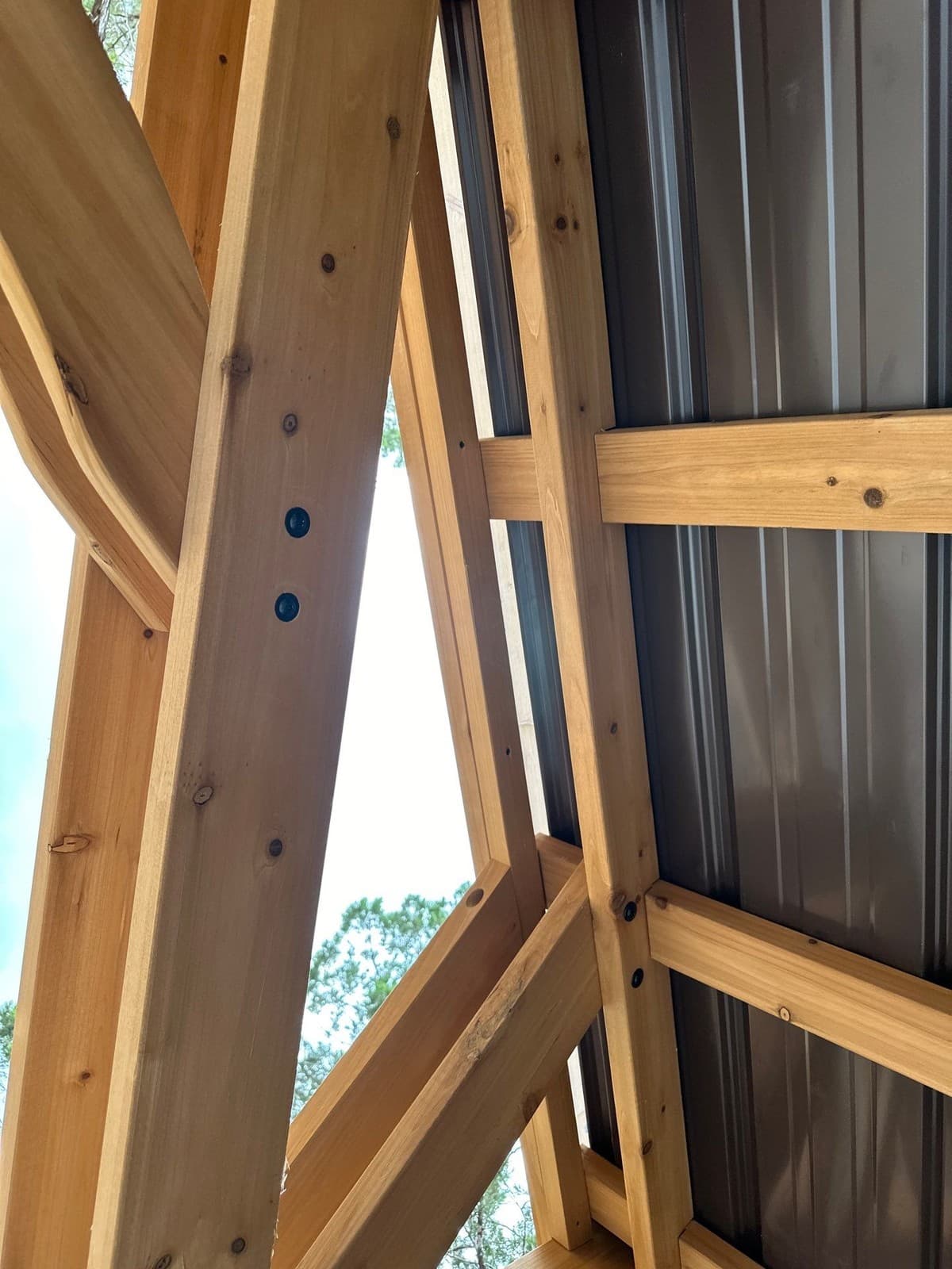Post anchor installation on existing patio slab for pergola construction — drilling and epoxy bolt detail
