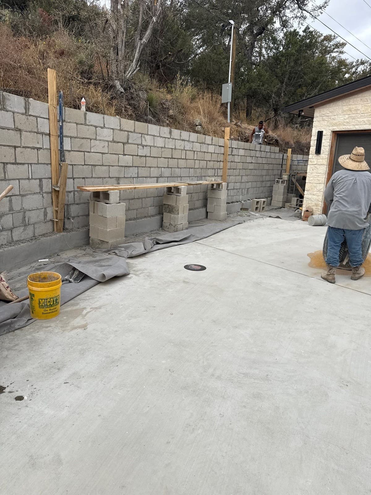 Engineered retaining wall cross-section for walls exceeding 4 feet — geogrid layers, batter, and drainage pipe