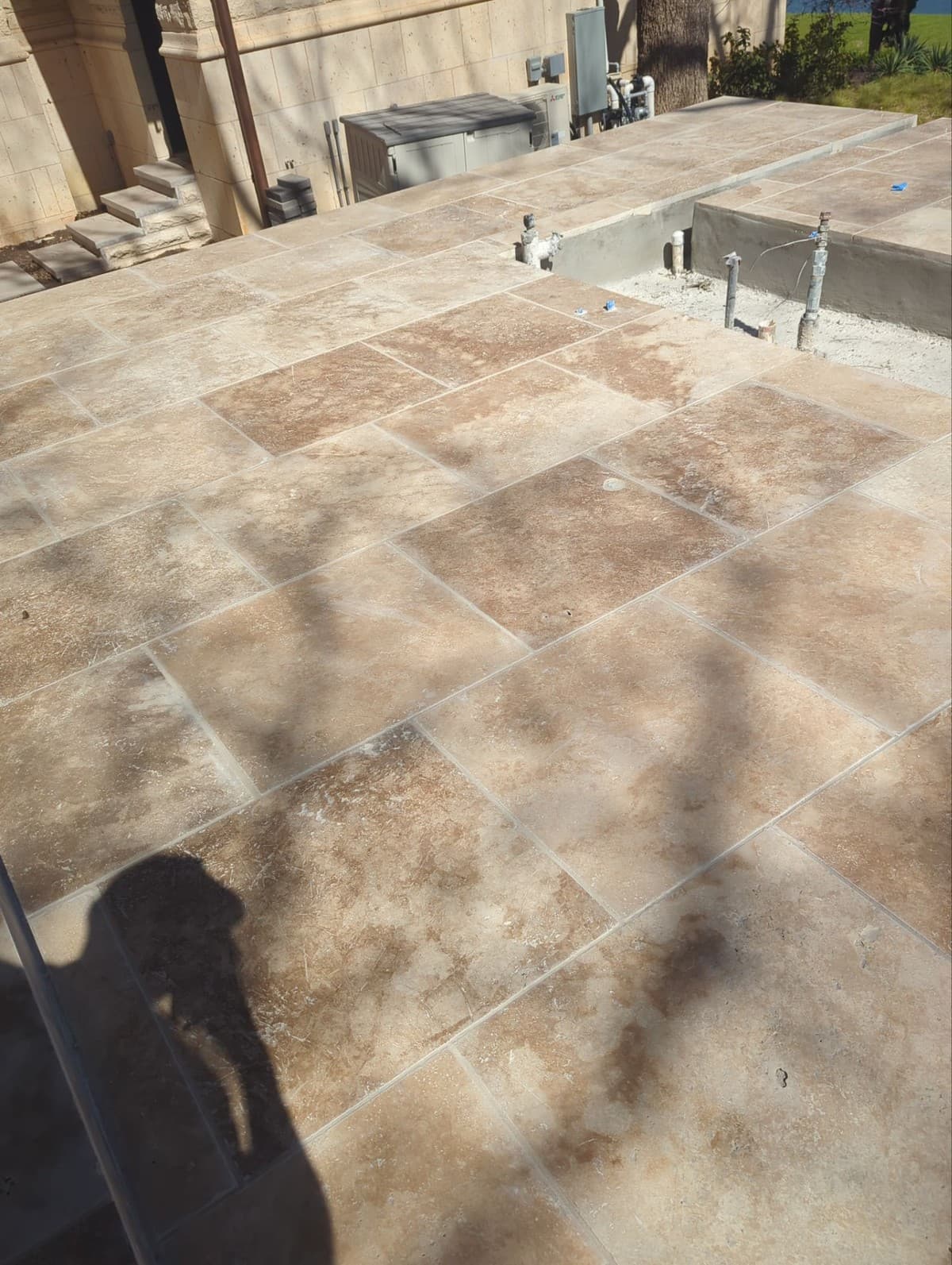 Paver patio cross-section detail showing compacted base depth, bedding sand, pavers, and polymeric sand joints