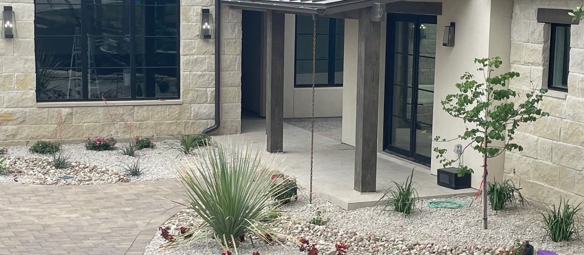Dry creek bed that drains and looks natural — rock placement, edging, and plant selection for Texas landscapes
