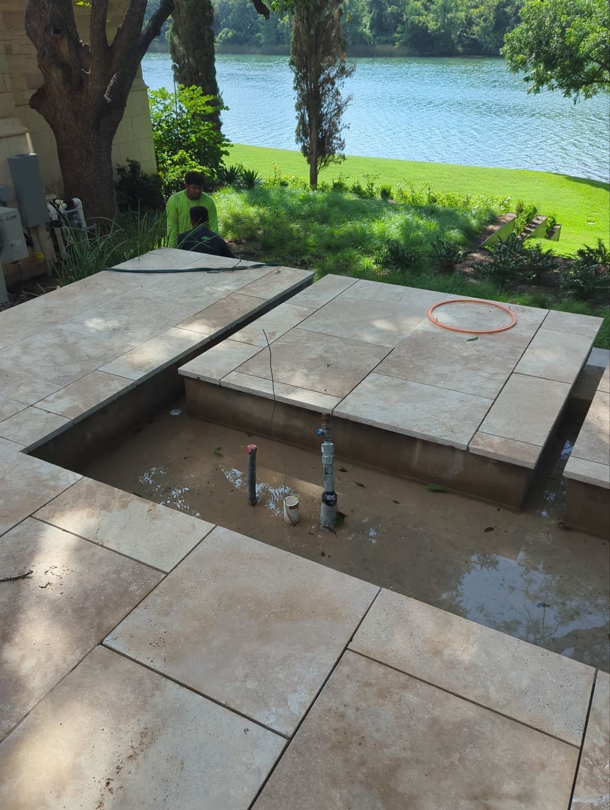 Estimating worksheet showing water feature excavation, liner, pump, electrical, and stone material costs