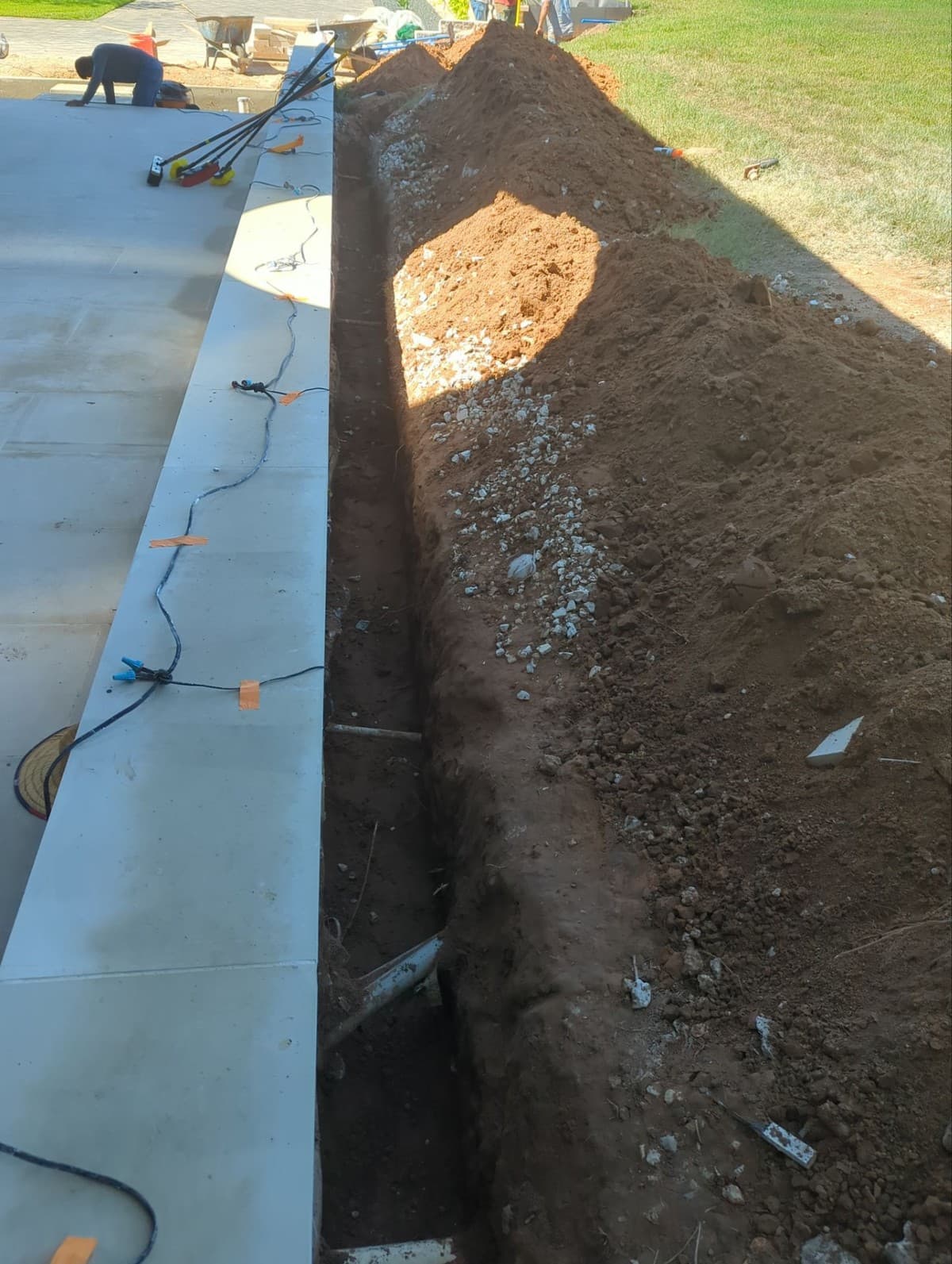 French drain pricing breakdown showing excavation, perforated pipe, drain rock, and filter fabric per LF