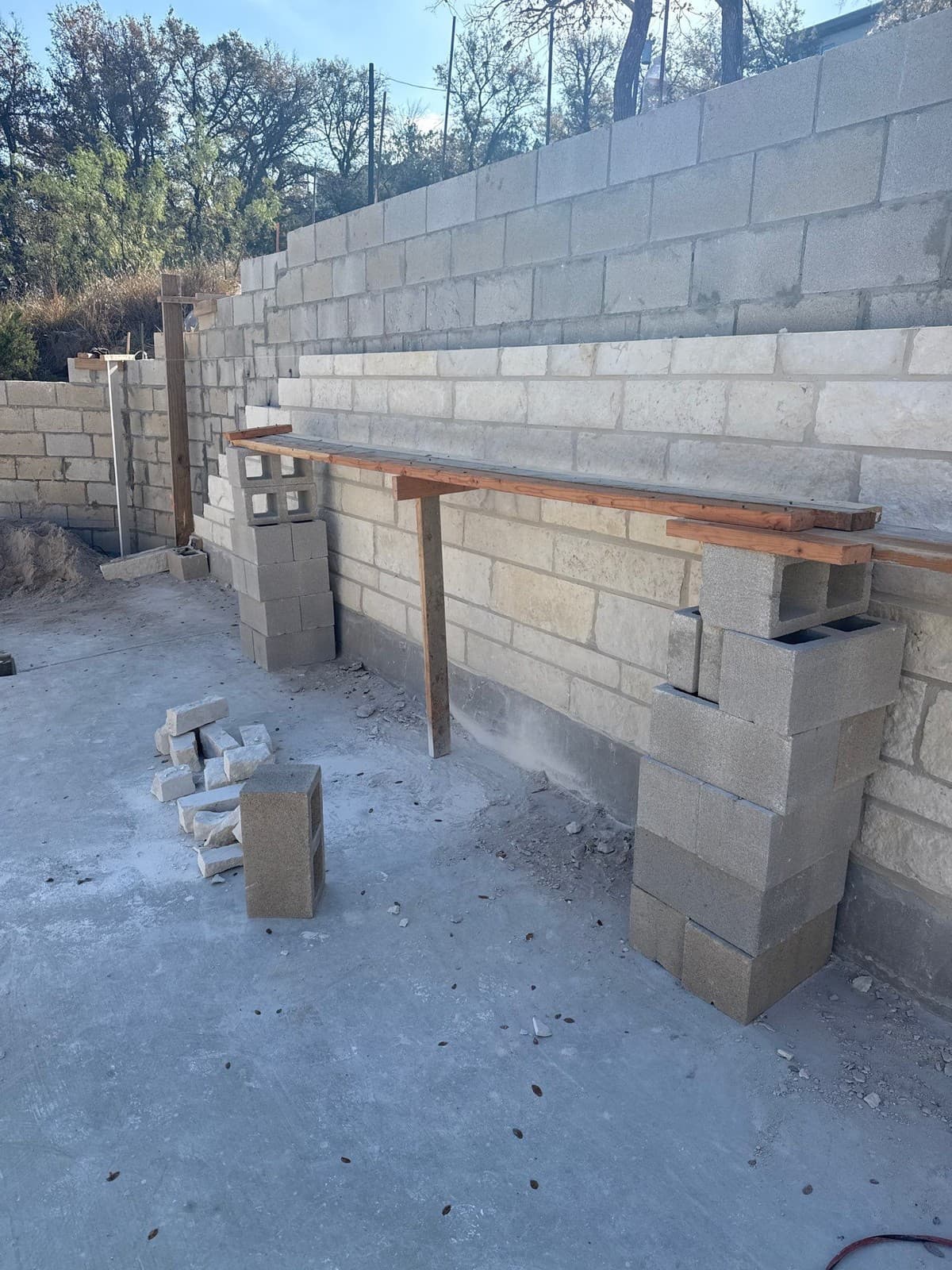 Tall retaining wall cost factors showing permit, engineering, geogrid layers, and additional drainage costs