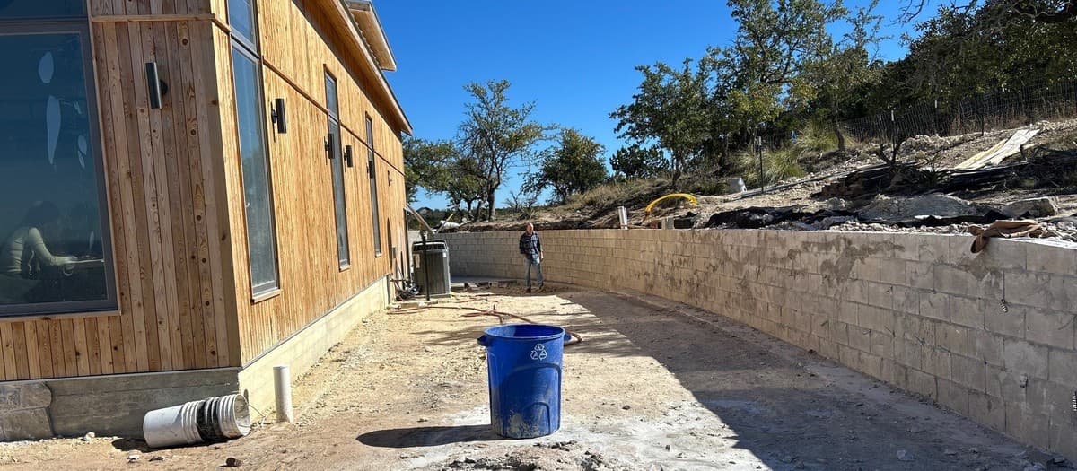Pricing a retaining wall over 4 feet — engineering, permits, geogrid, drainage, and labor premium