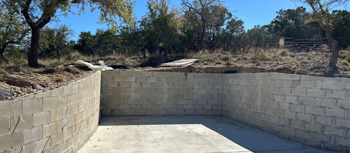 Retaining wall installation guide — excavation, base preparation, block coursing, and drainage installation