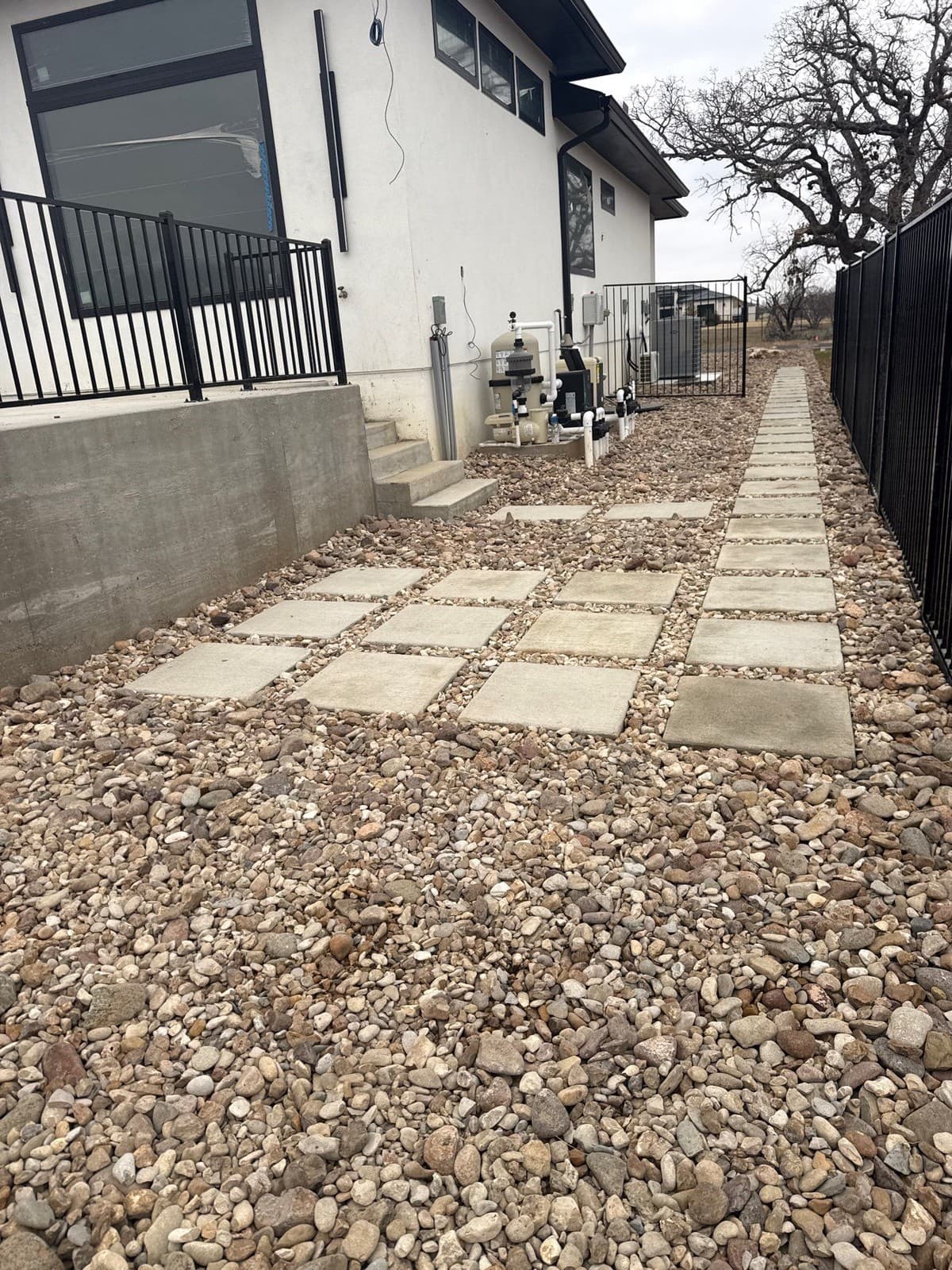 Stepping stone installation cross-section showing sand base depth, stone height above grade, and joint fill